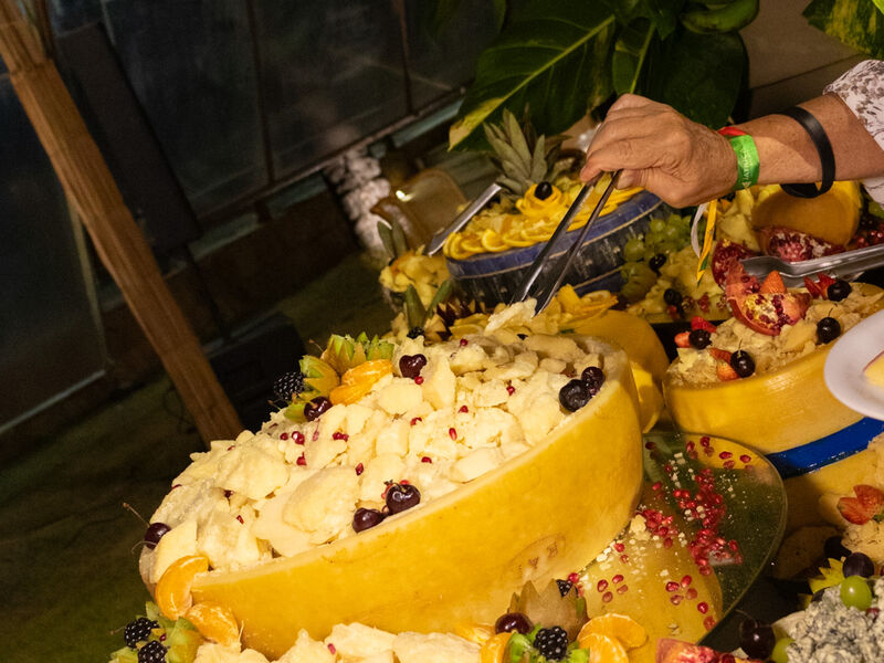 Sobremesa servida dentro de melão esculpido, com frutas vermelhas em volta.